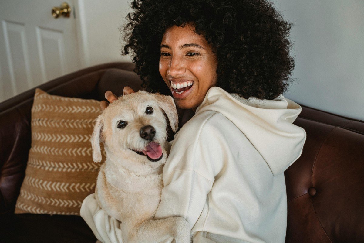 A young woman embraces her new dog.